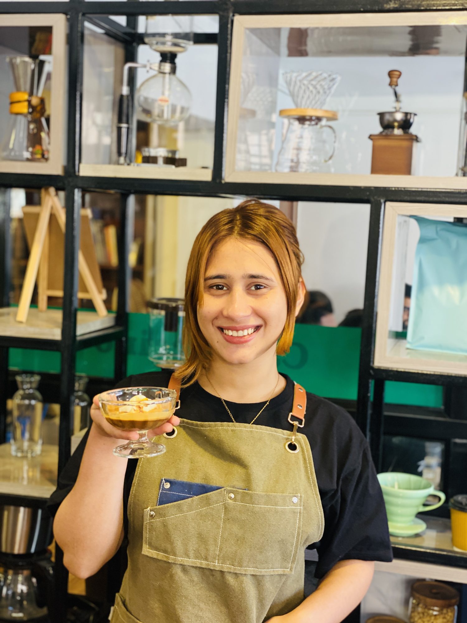 Barista at Hillside Beans holding a coffee